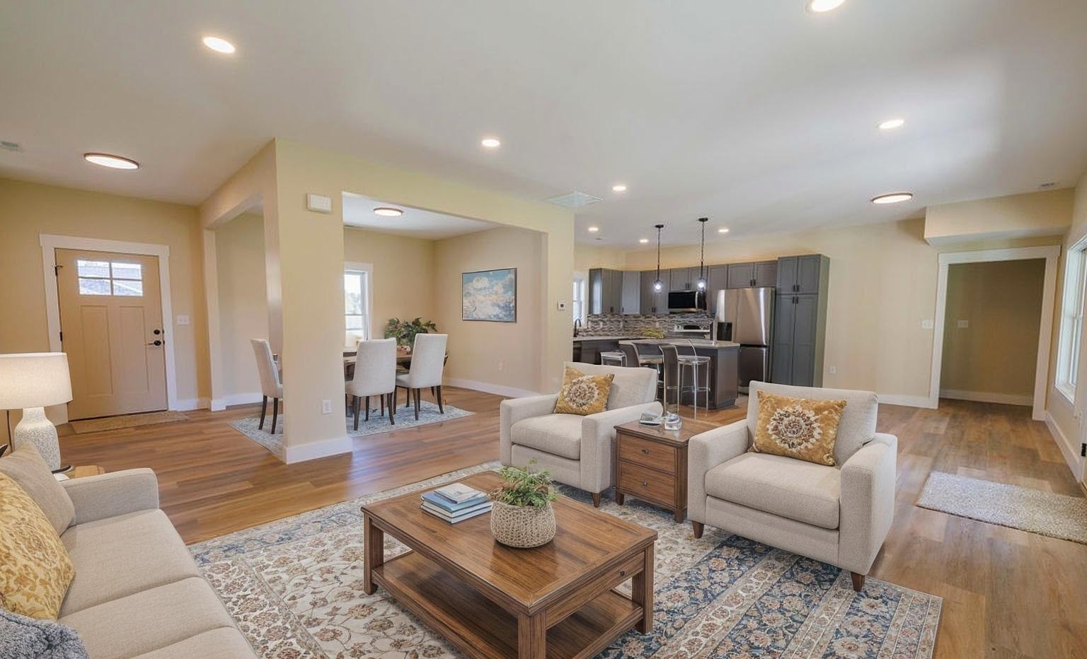 Bright open-concept living room and kitchen with neutral furnishings.